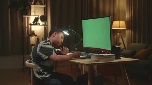 Bored Asian Boy Student Distance Learning With Mock Up Computer Green Screen From Home