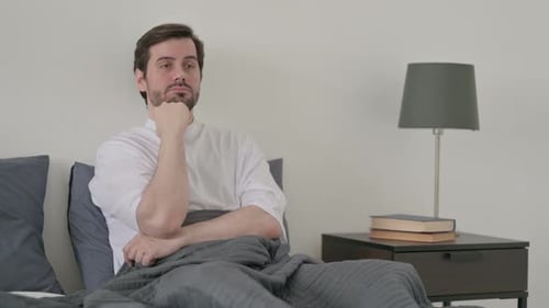 Young Man Taking Nap While Sitting in Bed