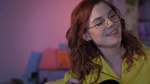 Woman Plays Acoustic Guitar and Sings at Home