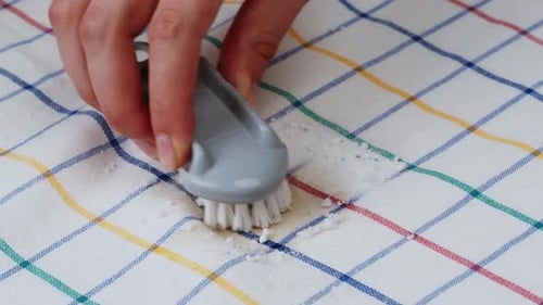 Hand Scrubs Stain with Brush on Tablecloth