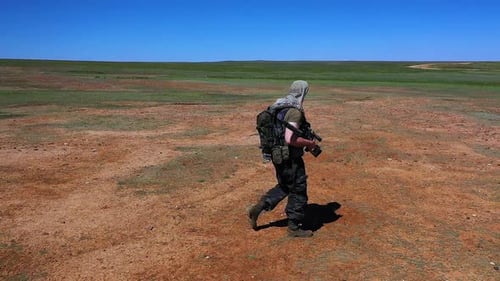 Slow Motion Tired Soldiersniper Walks Across the Scorching Desert Land