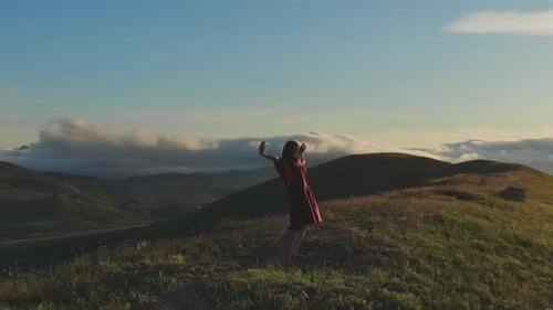 Woman Dances Barefoot on a Beautiful Hilltop at Sunrise