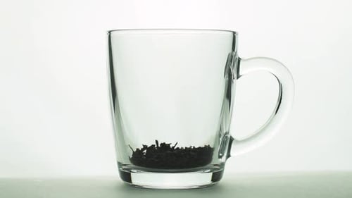 Close Up Tea Leaves Brewing in Glass Mug
