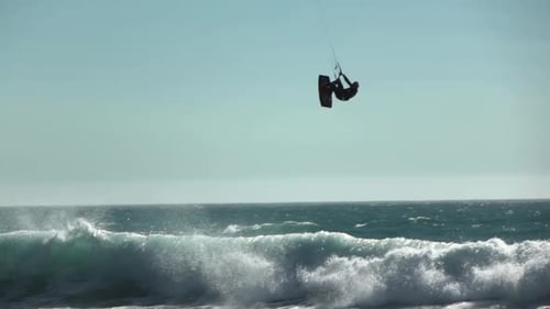 Kitesurfer Soaring High Above Ocean Wave