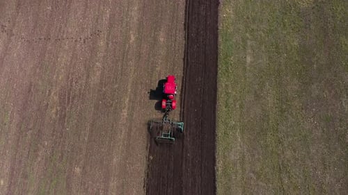 Red Tractor Working at Field