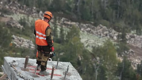 An Unrecognizable Builder Stands