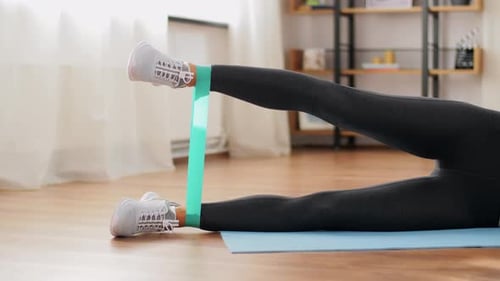 Woman Lying Doing Resistance Band Exercise