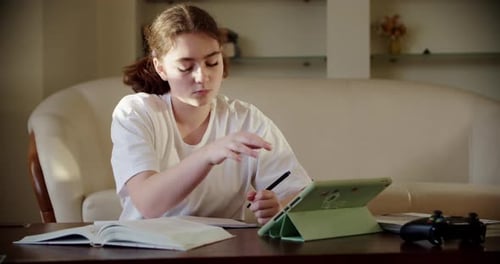 Girl Studying at Home with Book and Tablet