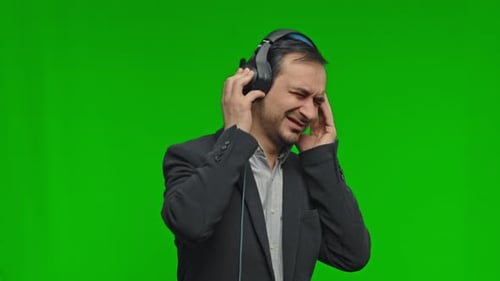 Adult Enjoys Music with Headphones on Green Screen