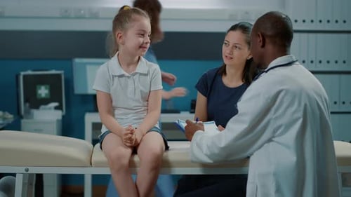 Girl Speaking with Doctor in Examination Room