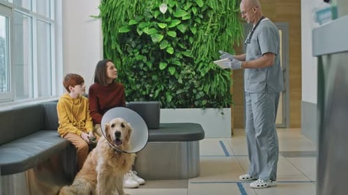 Boy and Woman at Veterinarian Visit with Golden Retriever