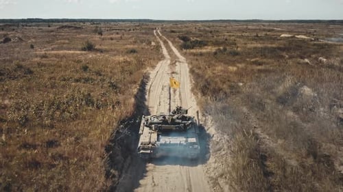 Tank Traveling Down Rural Road Seen From Above