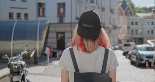 Fashionable Beautiful Teenager Girl with Trendy Colorful Hair Walking Along Street of City, Back