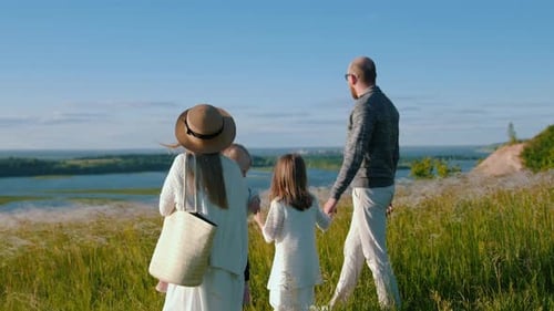 Young Happy Family Walking Down the Hill To the River and Enjoying the View
