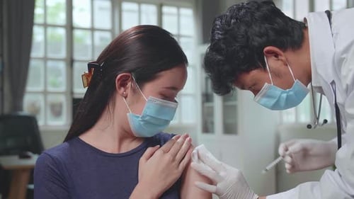 Young Woman Receives Injection from Medical Professional
