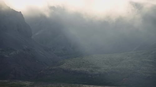 Nuages ensoleillés et brume se déplaçant au-dessus des montagnes