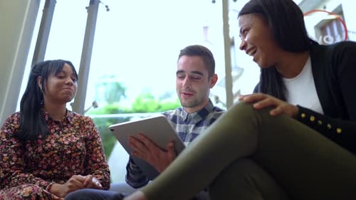 Laughing Friends Looking at a Tablet Together