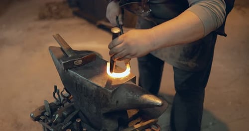 Blacksmith Forming Red Hot Metal Horseshoe on Anvil