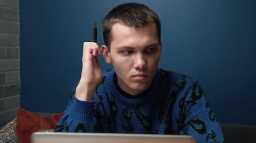 Thoughtful Serious Young Caucasian Man Student Writer Sits Home Office Desk Laptop Thinking