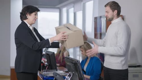 Side View of Woman Giving Fired Man Cardboard Box for Packing
