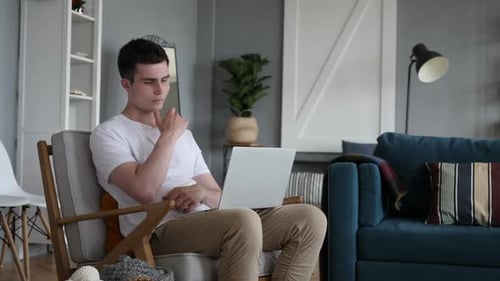 Young Man Using Laptop in Modern Home