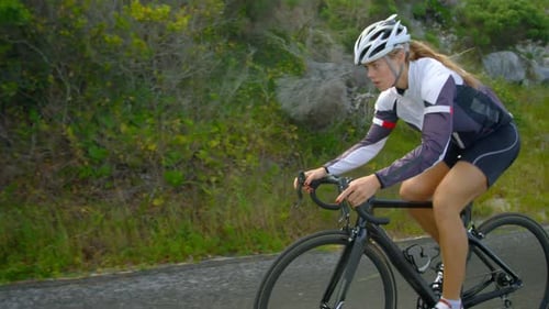 Female cyclist cycling on a countryside road 4k