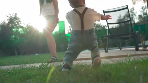 Toddler Falls on Soft Grass and Gets Up Running to Mother