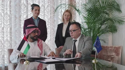 Businessmen Signing International Agreement at Corporate Meeting