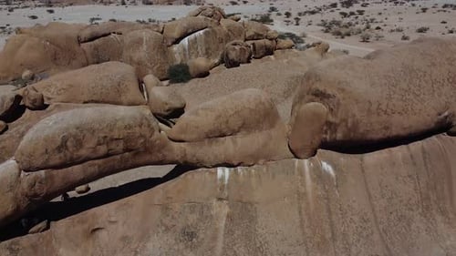 Big round rocks and people exploring, huge Erongo mountain on the background
