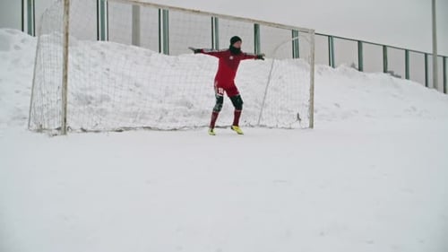 Goalkeeper Dives to Save in Winter Snow