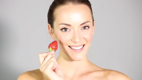 Woman Eats Strawberry in Close Up Beauty Shot