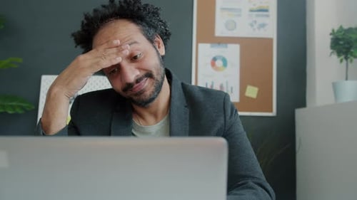 Overworked Office Worker Using Laptop and Touching Head Suffering From Pain in Workplace