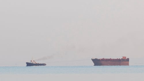 Tugboat Tugging a Large Barge in an Overcast Day
