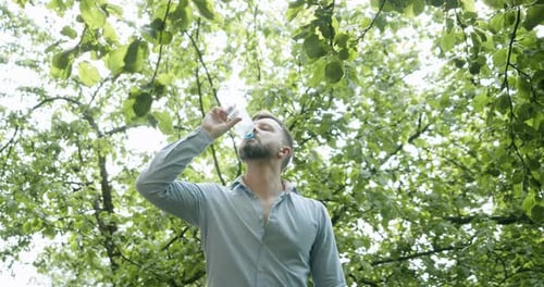 Man Drinks Water Then Trash Falls Around Him