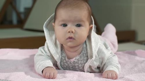 Adorable Baby Wearing Hoodie Lying on Blanket