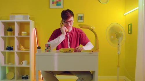 Young Adult on Yellow Landline in Yellow Room