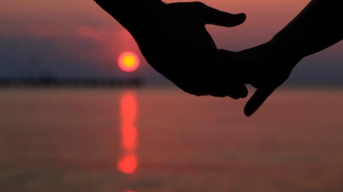 Couple Holding Hands at Sunset