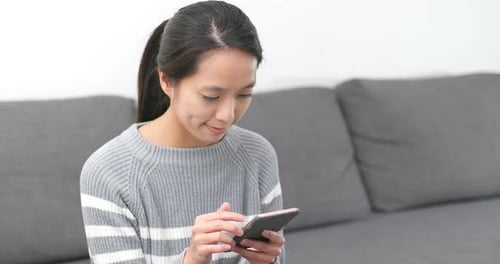 Woman Using Smart Phone Device on Couch