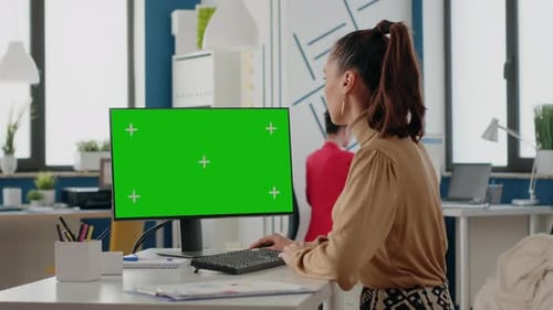 Person Working with Green Screen on Computer