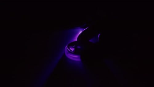 A bitcoin on a dark background is illuminated with a contrasting light