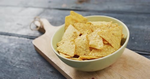 Vista de cerca de un tazón de nachos en una bandeja de madera con espacio para copiar en una superficie de madera