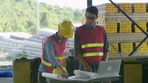 Engineers Collaborating Over Construction Plans On-Site