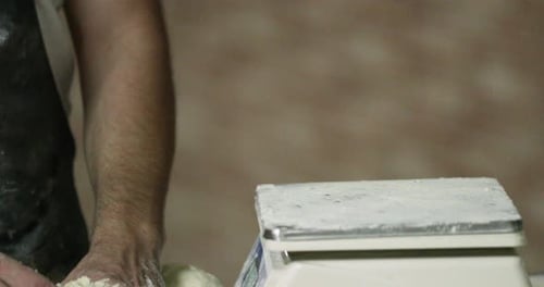 Hands Of A Baker Weighing The Kneaded Dough On A Baking Scale In The Bakery. - close up shot