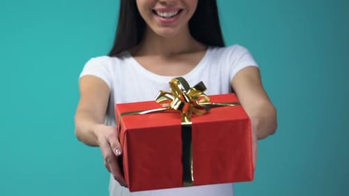 Smiling Woman Holds Out Birthday Gift