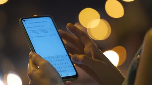 Hands Using Mobile Phone Map Application at Night