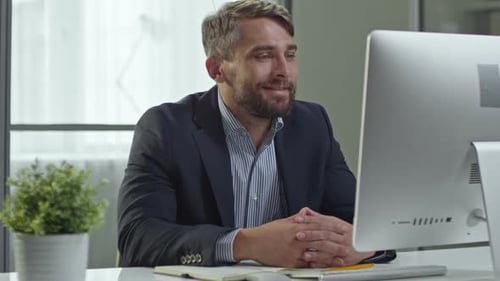 Man Talking at Computer in Office Setting