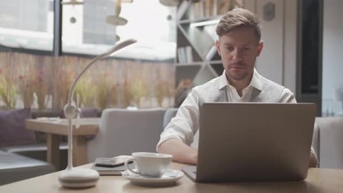 Homme d'affaires assis et travaillant dans un café. Homme utilisant un ordinateur.