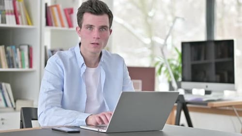 Man Shocked at Laptop News in Office