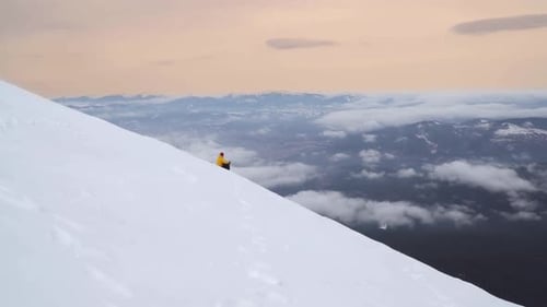 Hiker Sitting on Snowy Mountain Slope