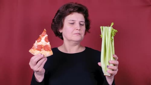 Woman Holds Pizza and Celery Slice